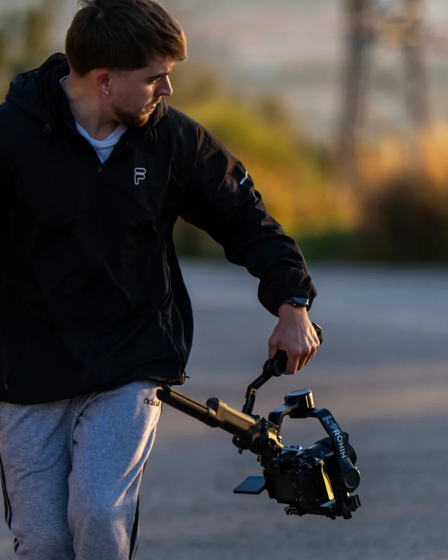 Iago Martínez caminando con un gimbal durante un rodaje al atardecer