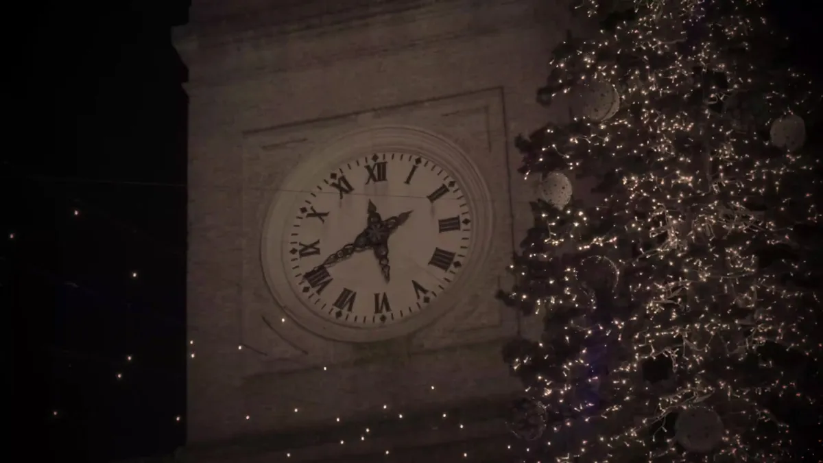 Torre del reloj iluminada junto a un árbol de Navidad en Macerata